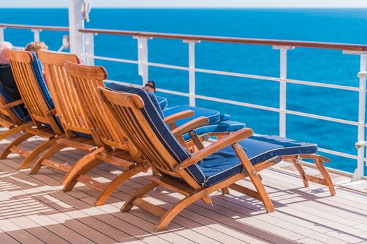 Ocean Liner Cruising. Wooden Deck Chairs and Some Tourist on Route to Destination.