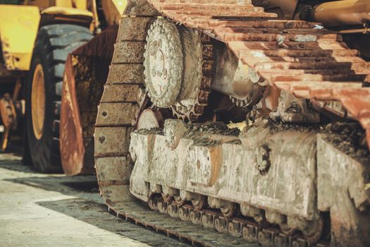 Industrial Theme. Heavy Duty Construction Equipment Closeup Photo. Bulldozer and Loader in the Background.