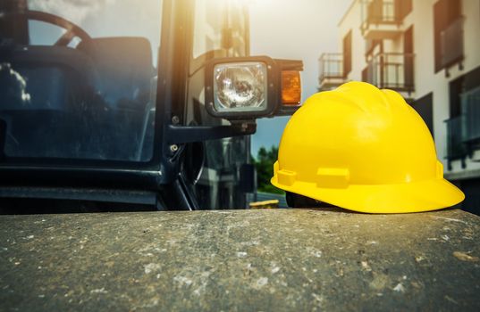 Yellow Hard Hat on the Construction Roller. Heavy Equipment Operation Safety. Industrial Theme.