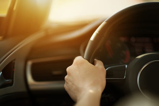 Modern Sporty Car Handling Concept Photo. Caucasian Men Driving His Car. Hand on Steering Wheel Closeup.