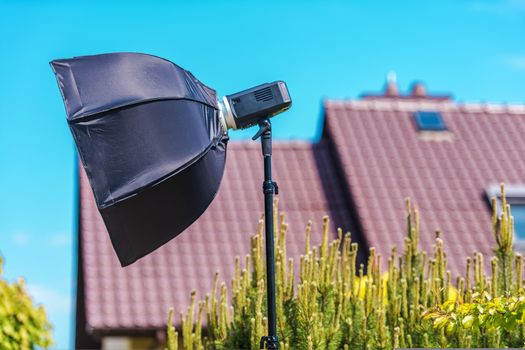 Outdoor Professional Photography Lighting. Strobe Light with Softbox on a Stand. 