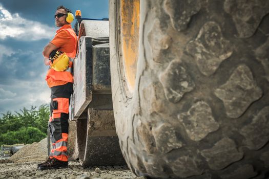 Caucasian Road Roller Operator Worker in His 30s. Construction Heavy Equipment.