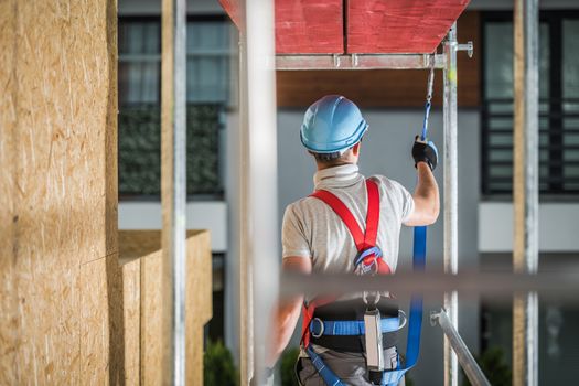 Safe Construction Work While on a Scaffolding. Safety Harness Equipment Concept. Industrial Theme.