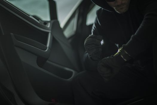 Suspicious Men with Small Flashlight in a Car. Vehicle Theft or Robbery Concept Photo.