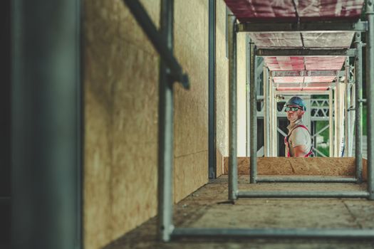 Contractor Worker on a Scaffolding Preparing For His Job. Construction Industry Safety.