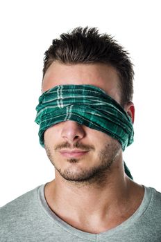 Handsome blindfolded young man with eyes covered. Concept of confusion, problem, challenge, losing your way. Isolated on white