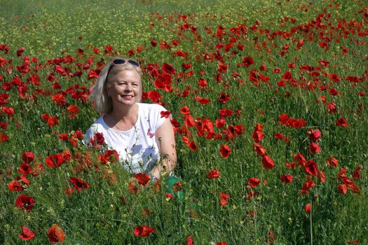 The Romanian Plain at the beginning of the summer.
Carpets poppy cover the wheat fields
A woman stopped to enjoy the image of the poppy in the fields of green wheat