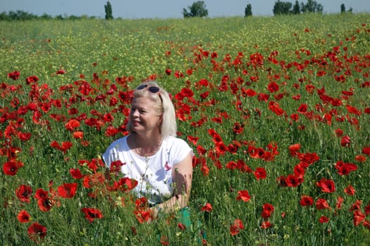 The Romanian Plain at the beginning of the summer.
Carpets poppy cover the wheat fields
A woman stopped to enjoy the image of the poppy in the fields of green wheat