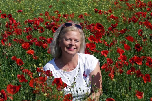 The Romanian Plain at the beginning of the summer.
Carpets poppy cover the wheat fields
A woman stopped to enjoy the image of the poppy in the fields of green wheat