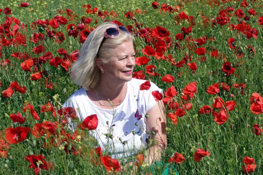 The Romanian Plain at the beginning of the summer.
Carpets poppy cover the wheat fields
A woman stopped to enjoy the image of the poppy in the fields of green wheat