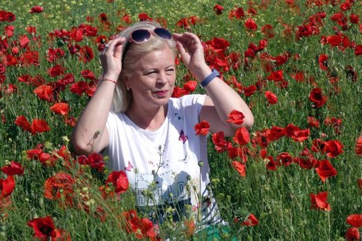 The Romanian Plain at the beginning of the summer.
Carpets poppy cover the wheat fields
A woman stopped to enjoy the image of the poppy in the fields of green wheat