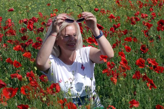 The Romanian Plain at the beginning of the summer.
Carpets poppy cover the wheat fields
A woman stopped to enjoy the image of the poppy in the fields of green wheat