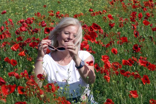 The Romanian Plain at the beginning of the summer.
Carpets poppy cover the wheat fields
A woman stopped to enjoy the image of the poppy in the fields of green wheat