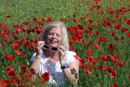 The Romanian Plain at the beginning of the summer.
Carpets poppy cover the wheat fields
A woman stopped to enjoy the image of the poppy in the fields of green wheat