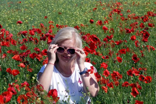 The Romanian Plain at the beginning of the summer.
Carpets poppy cover the wheat fields
A woman stopped to enjoy the image of the poppy in the fields of green wheat