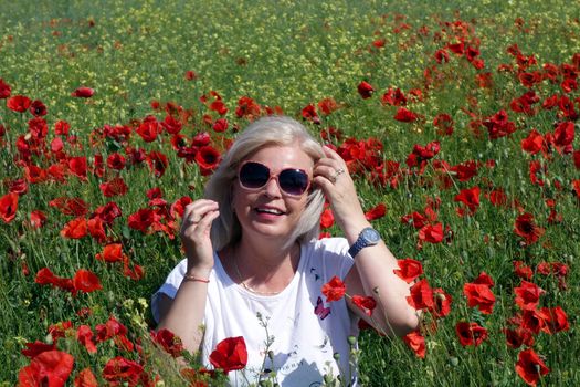 The Romanian Plain at the beginning of the summer.
Carpets poppy cover the wheat fields
A woman stopped to enjoy the image of the poppy in the fields of green wheat