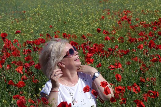 The Romanian Plain at the beginning of the summer.
Carpets poppy cover the wheat fields
A woman stopped to enjoy the image of the poppy in the fields of green wheat