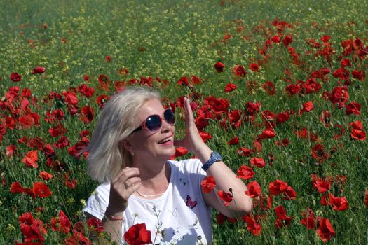 The Romanian Plain at the beginning of the summer.
Carpets poppy cover the wheat fields
A woman stopped to enjoy the image of the poppy in the fields of green wheat