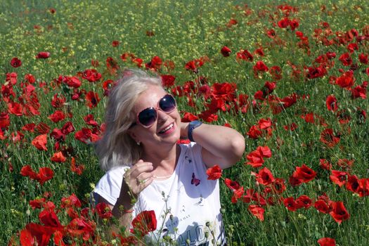 The Romanian Plain at the beginning of the summer.
Carpets poppy cover the wheat fields
A woman stopped to enjoy the image of the poppy in the fields of green wheat