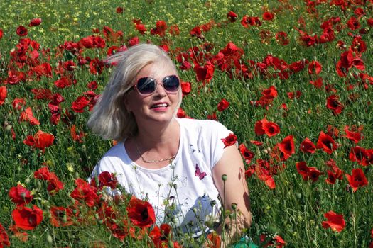 The Romanian Plain at the beginning of the summer.
Carpets poppy cover the wheat fields
A woman stopped to enjoy the image of the poppy in the fields of green wheat