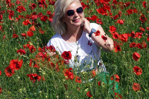 The Romanian Plain at the beginning of the summer.
Carpets poppy cover the wheat fields
A woman stopped to enjoy the image of the poppy in the fields of green wheat