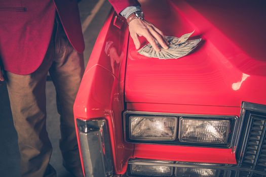 Buying Pre Owned Car. Men Placing Cash Dollars Deposit For the Old Classic Car. Closeup Photo. 