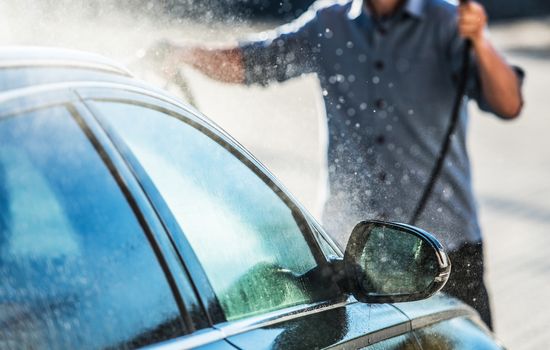 Caucasian Men Cleaning Vehicle in the Car Wash. Closeup Photo. Automotive Theme.