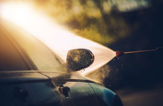 Car Washing Process Closeup Photo Concept. Detailed High Water Pressure Car Body Cleaning