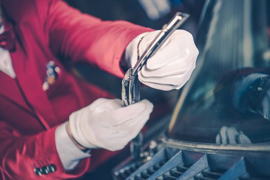 Classic Car Parts Replacement. Men in White Gloves Replacing Windshield Wiper in His Clients Classic Vehicle.