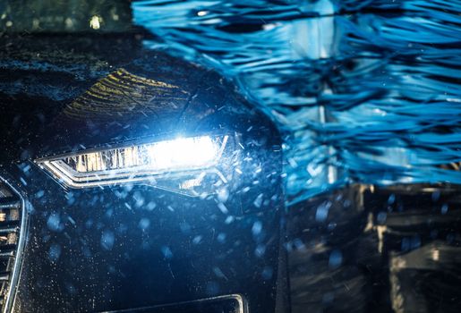 Modern Vehicle in the Automatic Brush Car Wash Closeup Photo.