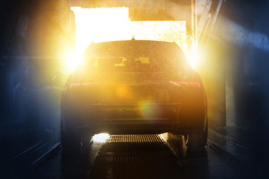 Summer Time Car Washing. Modern Vehicle in the Automatic Brush Car Wash During Scenic Sunset.