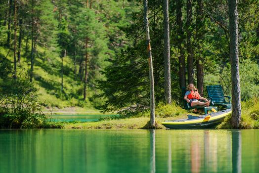 Vacation with the Kayak. Caucasian Woman in Her 30s Relaxing on the Small Lake Island.