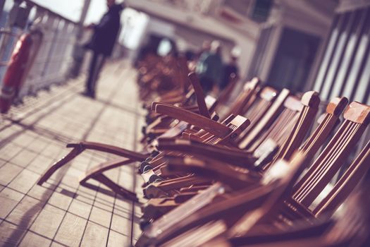Cruise Ship Travels Photo Concept. Wooden Deck Chairs on the Vessel Main Deck.