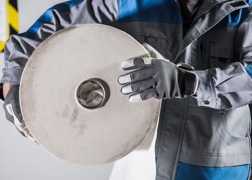 Worker with Large Roll of Industrial Use Paper. Closeup Photo