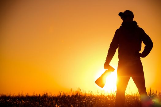 Outdoor Photographer Equipped with Large Telephoto Lens in the Remote Location During Scenic Sunset. 