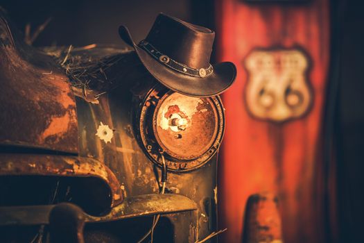 Route 66 Cowboys Concept. Cowboy Hat on the Rusty Classic Car with Broken Headlamp.