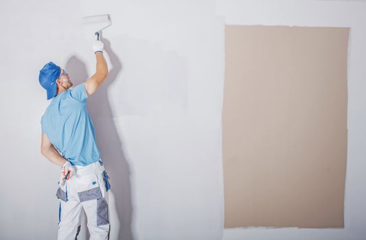 Room Painter at Work. Covering Darker Paint by Fresh and Lighter One. Apartment Renovation. Refreshing the Walls. Construction Theme.