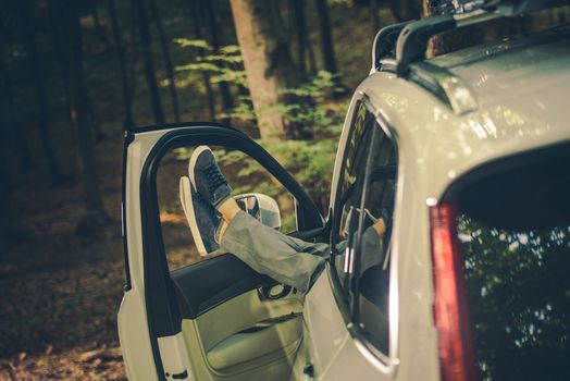 Men Relaxing with Legs Out of the Car Inside the Forest. Taking Short Break From Business Travel