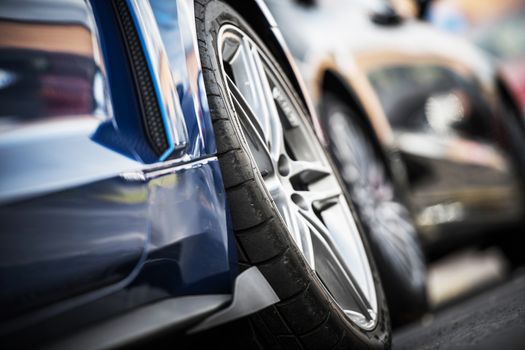 Car Alloy Wheels Closeup. Modern Vehicles on the Parking. Tire Closeup. Transportation Theme.