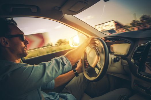 Car Drive with Motion Blur. Dynamic Driving on the Corners. Caucasian Driver in His 30s Inside the Modern Car.