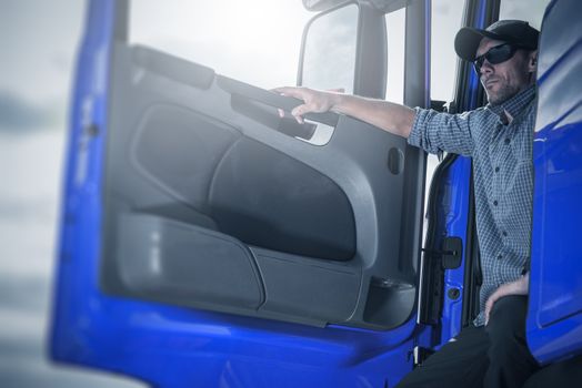 Proud Caucasian Trucker in His Semi Truck Taking Short Break Before Next Shipping Direction.