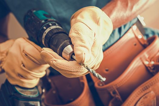 Contractor with Power Tool Closeup Photo. Cordless Driller in Hands of Caucasian Construction Worker.