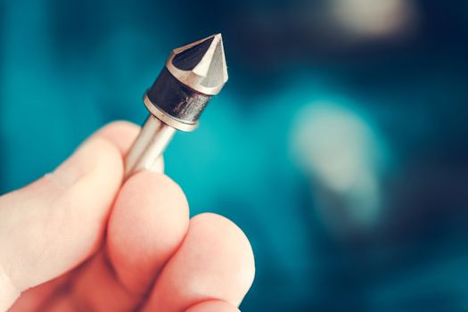 Iron Drill Bit in Contractor Hand. Closeup Photo. Industry Theme.