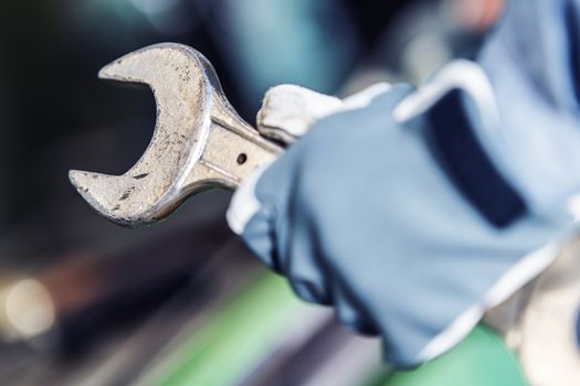 Mechanic Call to Action. Large Iron Wrench in Hand of Machinery Mechanic. Closeup Photo.