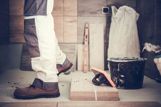 Worker Remodeling Bathroom. Installing New Ceramic Tiles. Construction Theme.