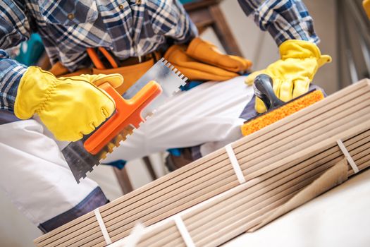 Ceramic Tiles Installer with Construction Tools. Closeup Photo.