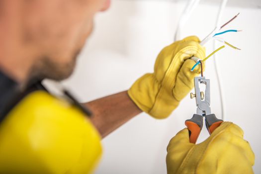 Building Proper Electrical System. Electric Technician Preparing Cables For the Outlet Installation.