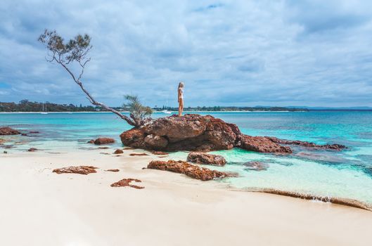 Beautiful idyllic beaches with turquoise water, luxury yachts and little rocky islands.  Woman on vacation in her own piece of paradise