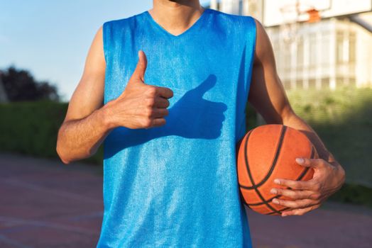 Athlete holding basketball ball with thumb up