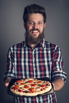 Happy smiling man holding home made pizza